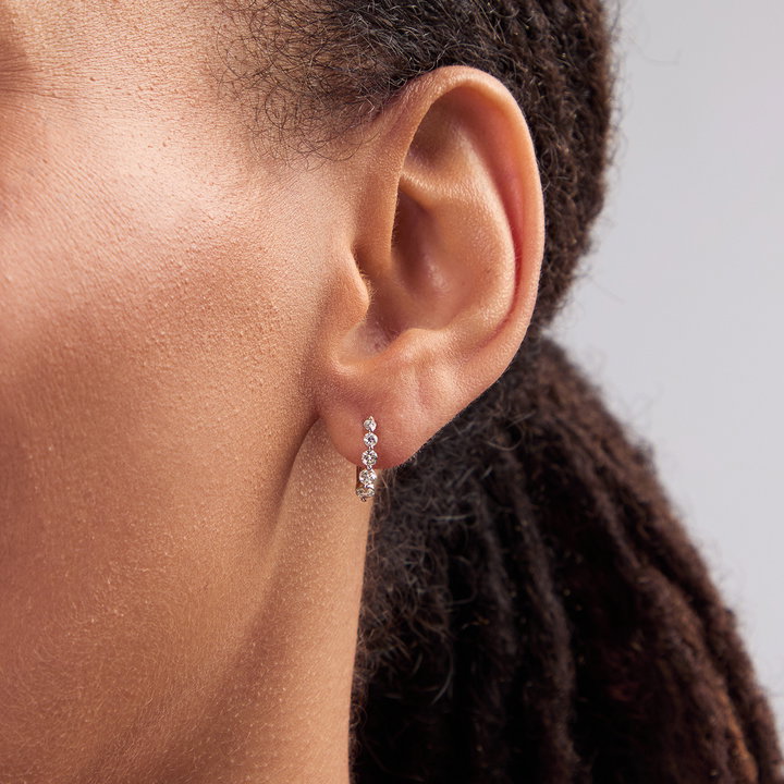 Shared Prong Graduated Diamond Huggie Earrings In Yellow Gold 14K