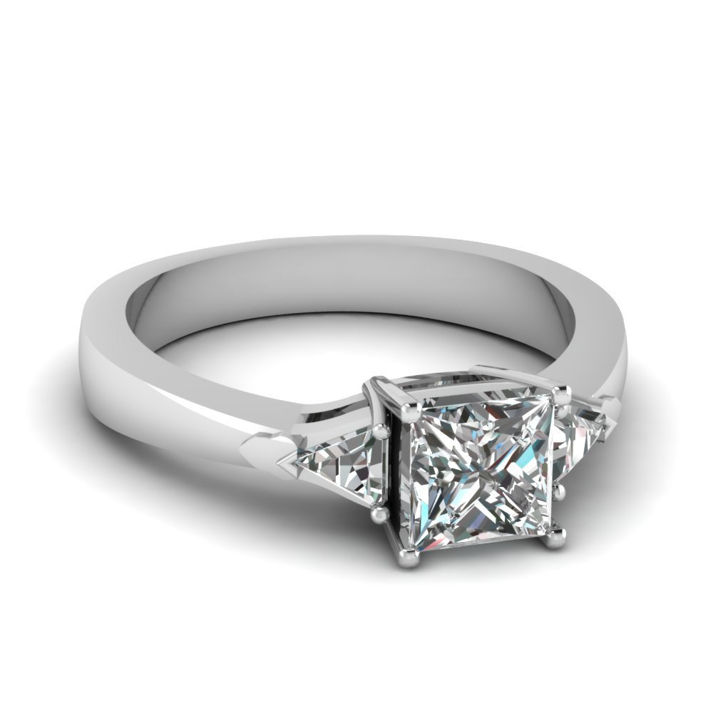 Oval diamond halo engagement ring with trillion shaped diamonds on the side  in white gold. - Goodman Jewelers